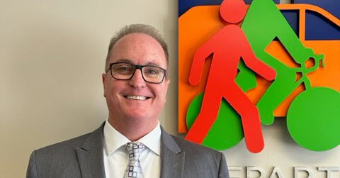 Image Ron E. Vicari, Director Department of Transportation​​ standing in front of transportation department  sign